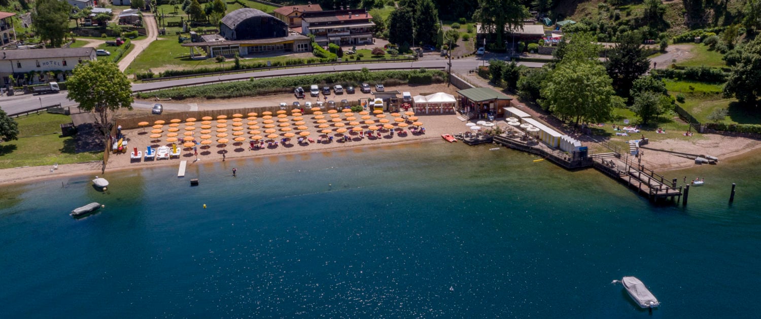 Aerial view of Alice Beach on Lake Maggiore with clear blue water and sandy shore